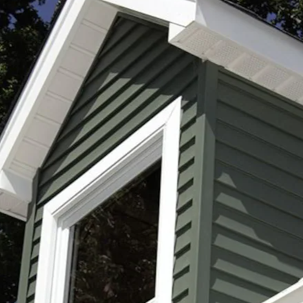 Vinyl siding grey color and white soffits installed in a gable